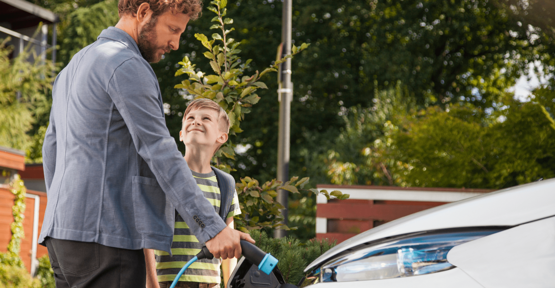 Man en kind laden elektrisch voertuig op - Arcadis Nederland