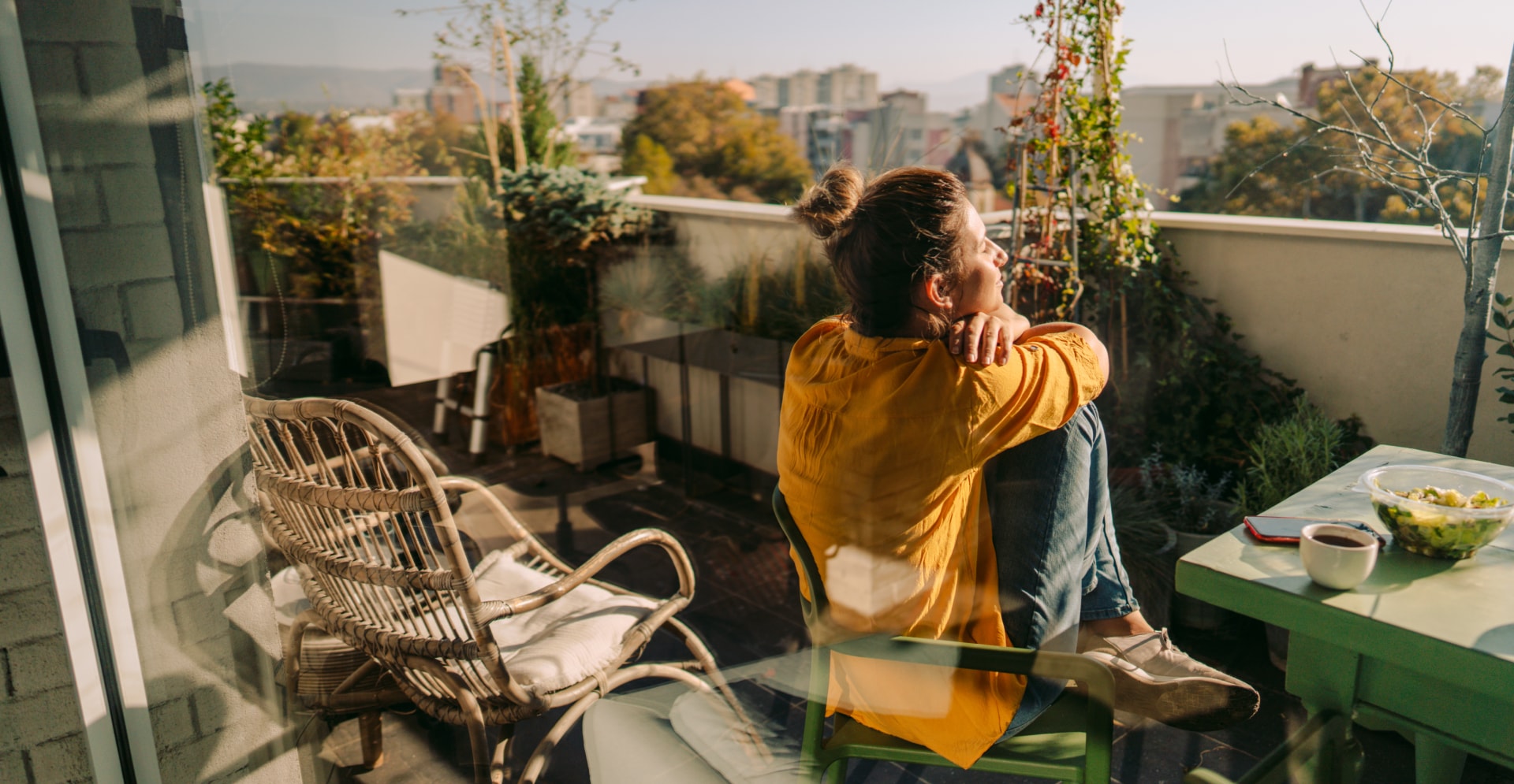 Vrouw geniet van uitzicht vanaf haar balkon. Natuur en biodiversiteit: basis voor duurzame leefomgeving