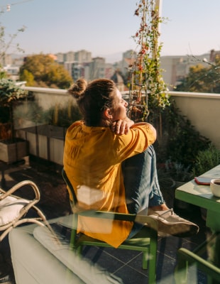 Natuur en biodiversiteit basis voor duurzame leefomgeving Vrouw geniet van uitzicht vanaf haar balkon. Natuur en biodiversiteit basis voor duurzame leefomgeving