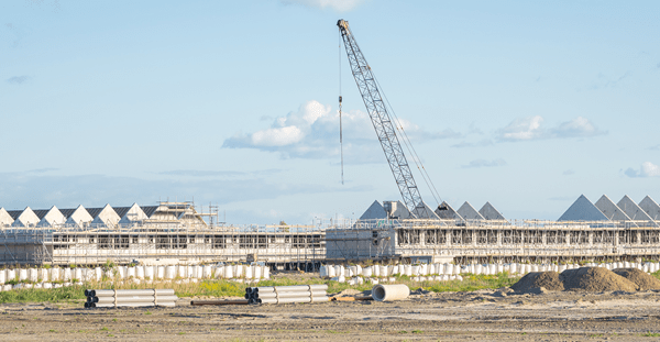 A large building under construction with a crane visible in the background, showcasing ongoing development work.