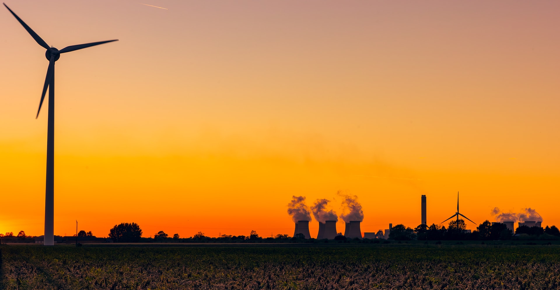 A wind turbine stands tall against a clear blue sky, showcasing renewable energy in a serene landscape.