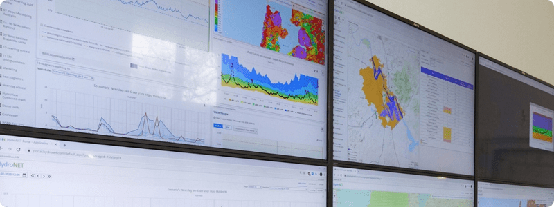 Multiple monitors displaying different data on a large screen.