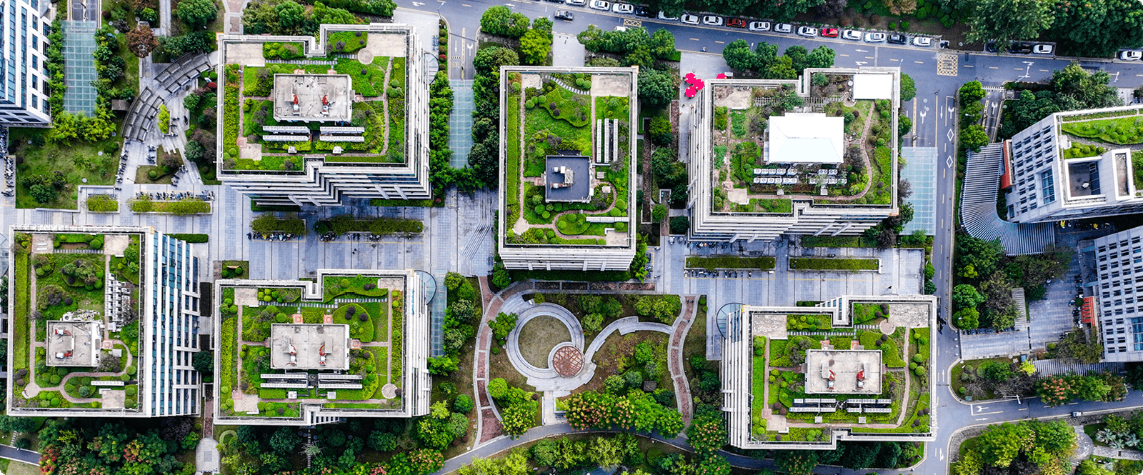 Aerial view of a city showcasing buildings with green roofs, highlighting urban greenery and sustainable architecture.