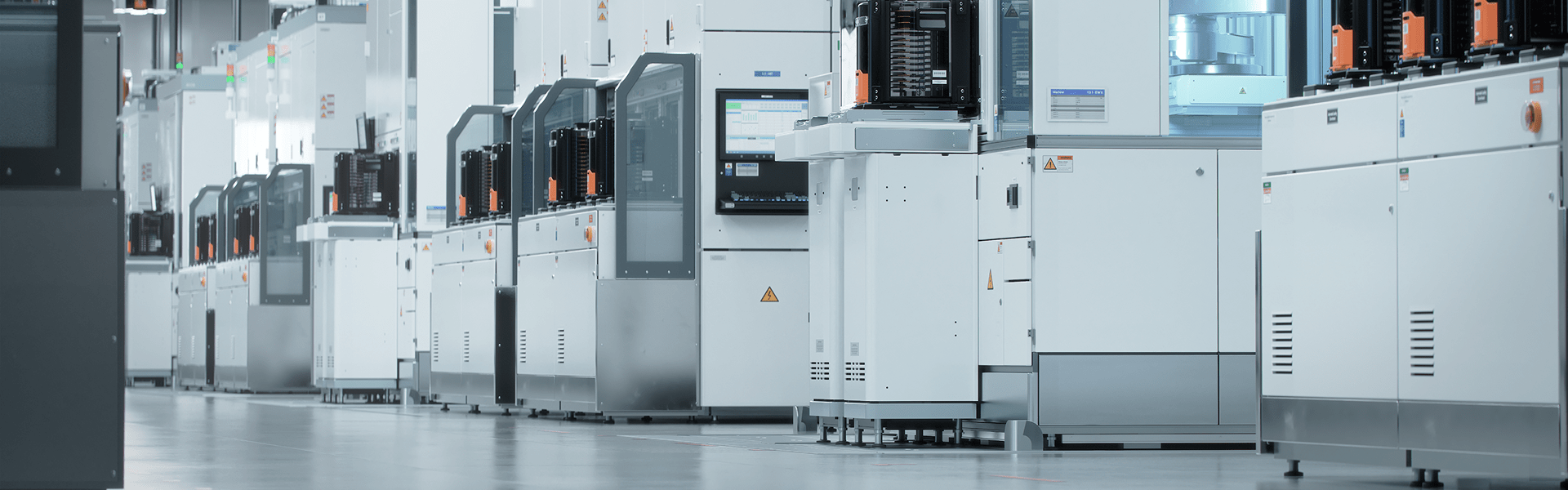 A row of industrial machines lined up in a factory setting, showcasing a workspace for manufacturing processes.