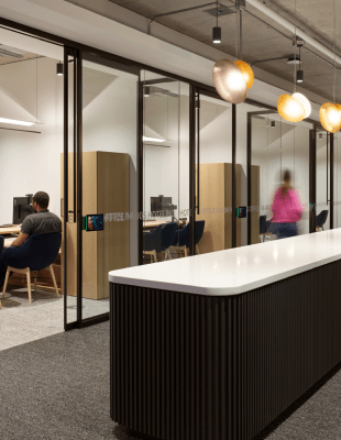 An office scene with several individuals engaged in work activities.