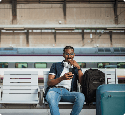 Man sitting on bench looking at phone