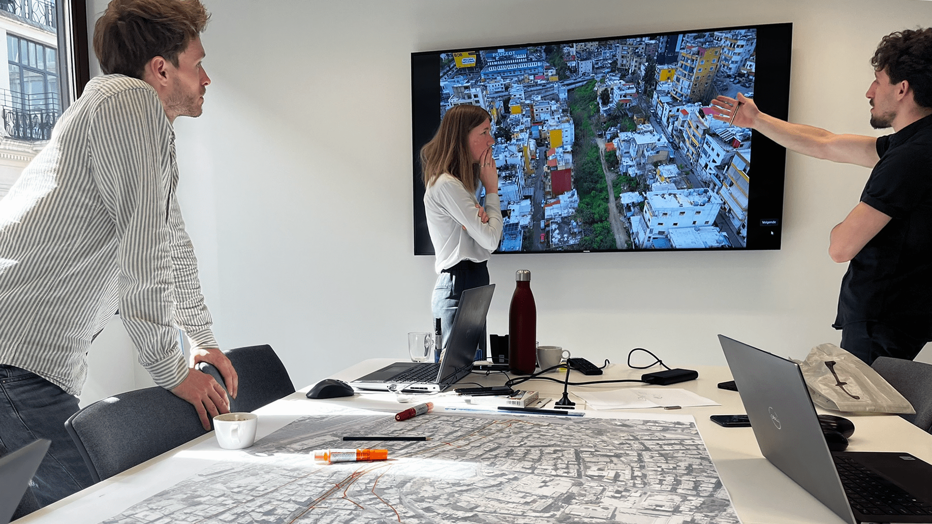 A group of diverse office workers collaboratively examining a large map on a table.