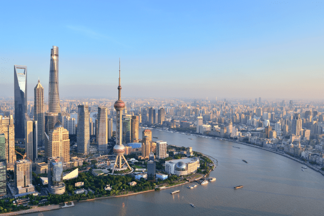 The image shows an aerial view of the Lujiazui financial district and the Huangpu River in Shanghai, China.