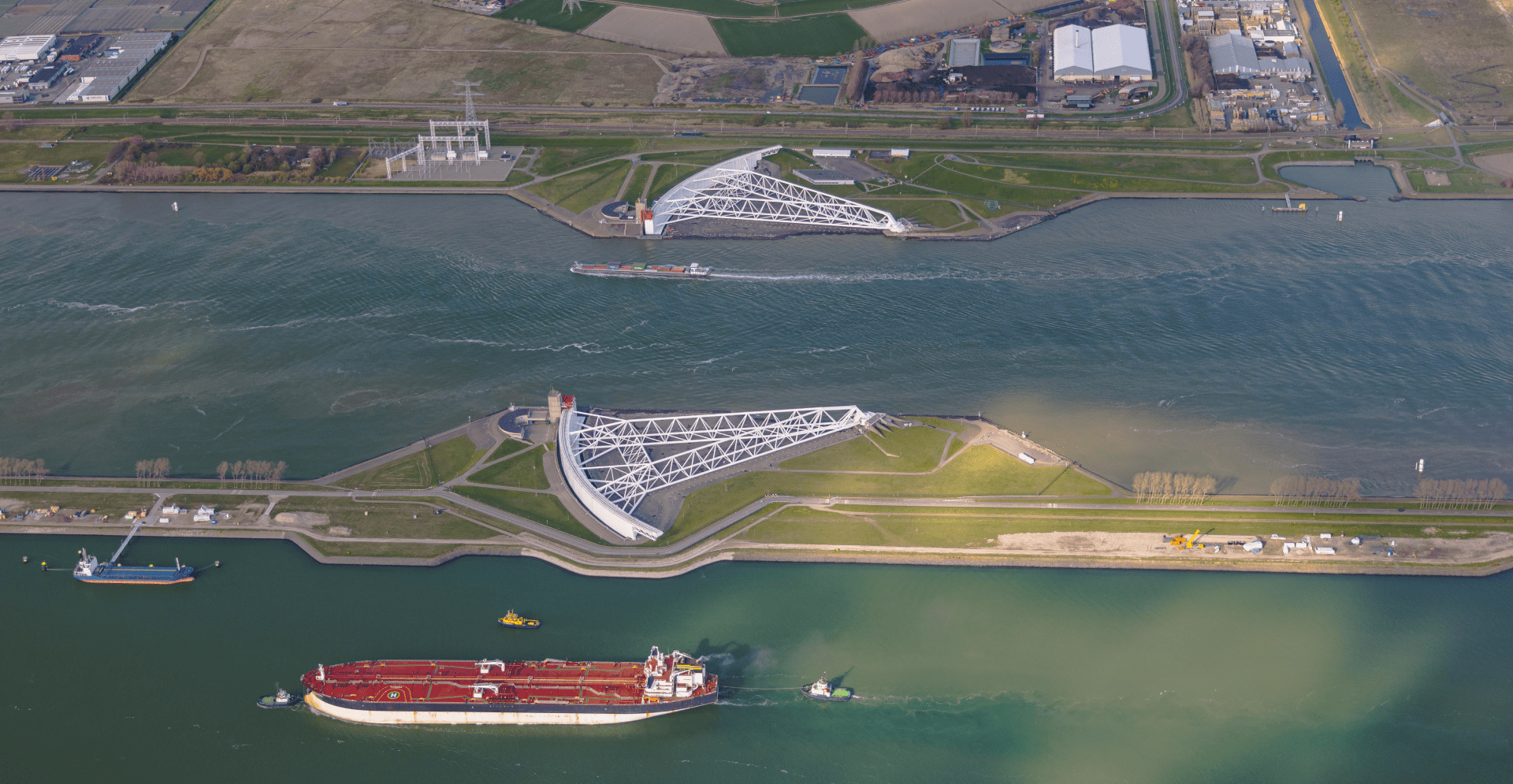 Ocean bordered by lush greenery and storm surge barriers.