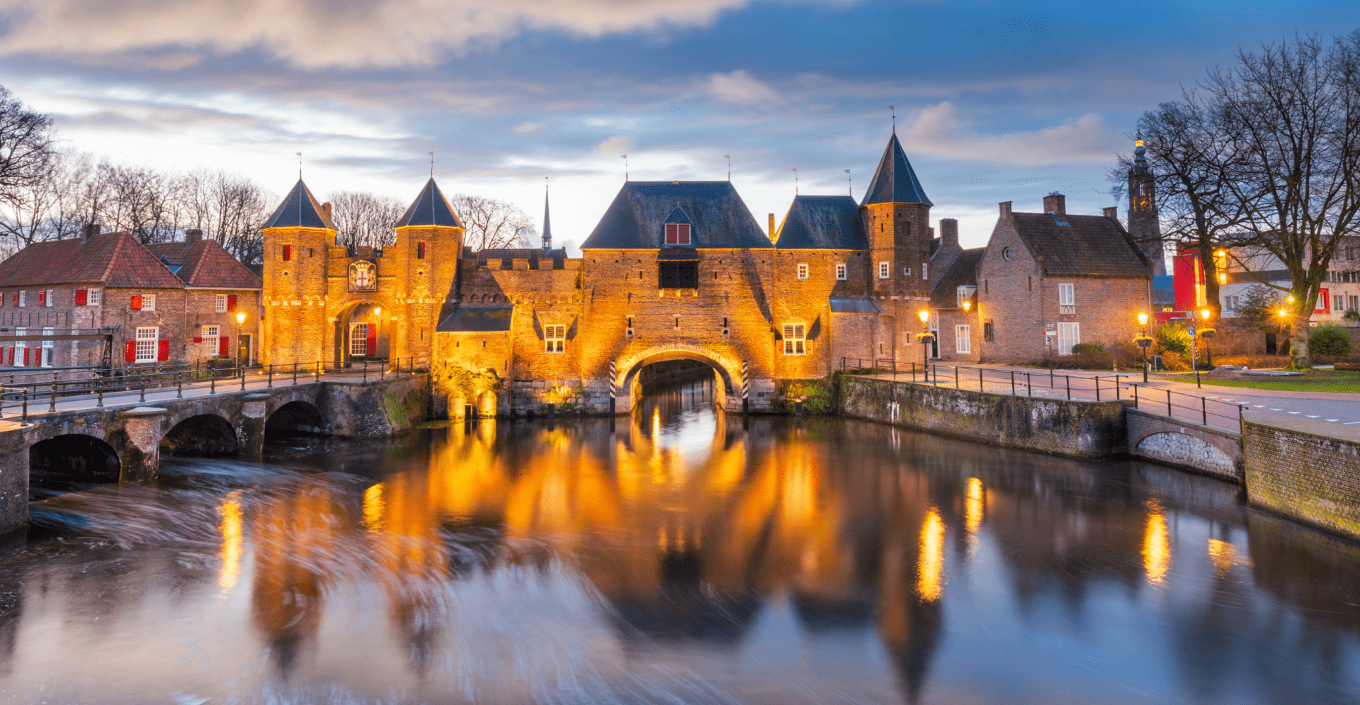 A picturesque castle located on an island in a river, framed by flowing water and vibrant foliage.