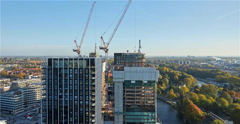 A panoramic view of a city skyline from the top of a tall building, showcasing urban architecture and distant landscapes.