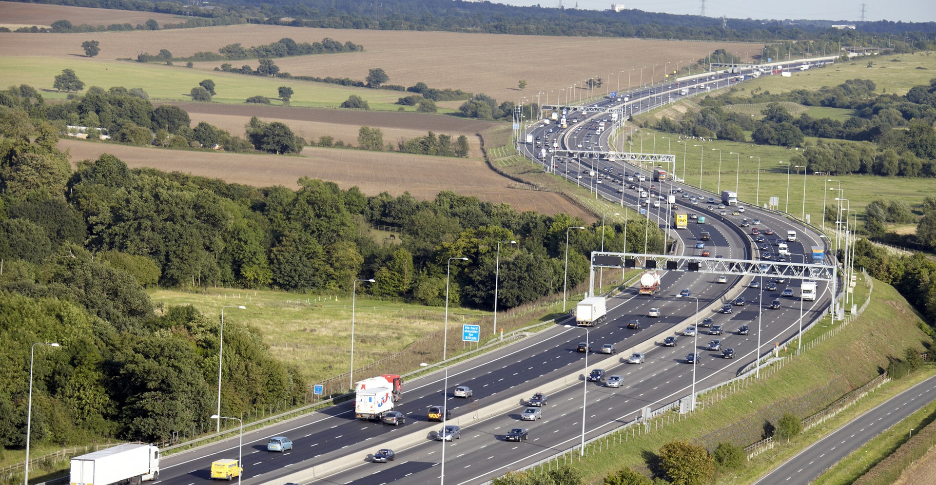 A crowded highway with many cars moving along, showcasing a typical day of traffic.