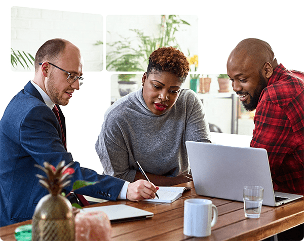 Three individuals seated at a table, engaged with a laptop, collaborating on a project or discussion.