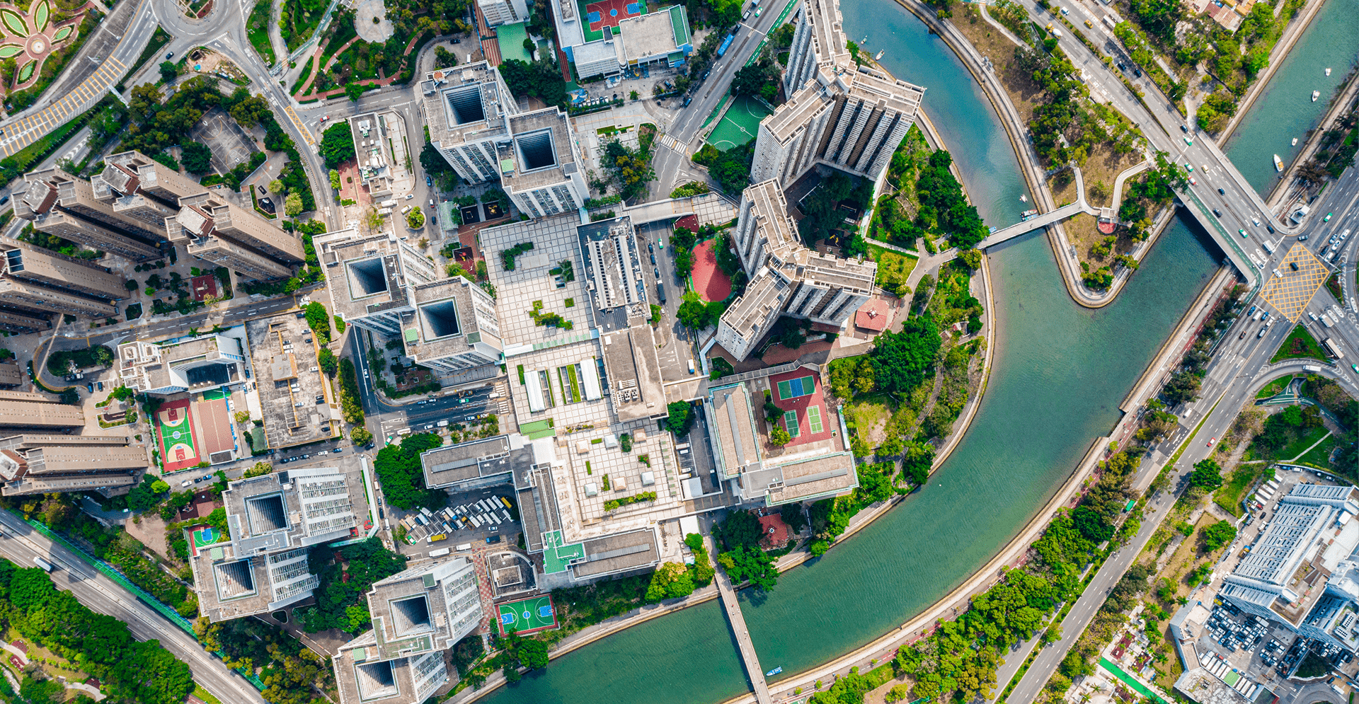 Aerial perspective of a city with a river meandering through its buildings and streets.