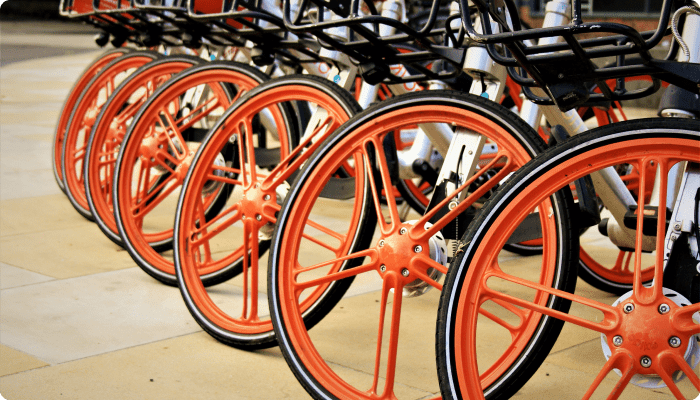 Several orange and black bicycles parked in a neat row, showcasing their vibrant colors.