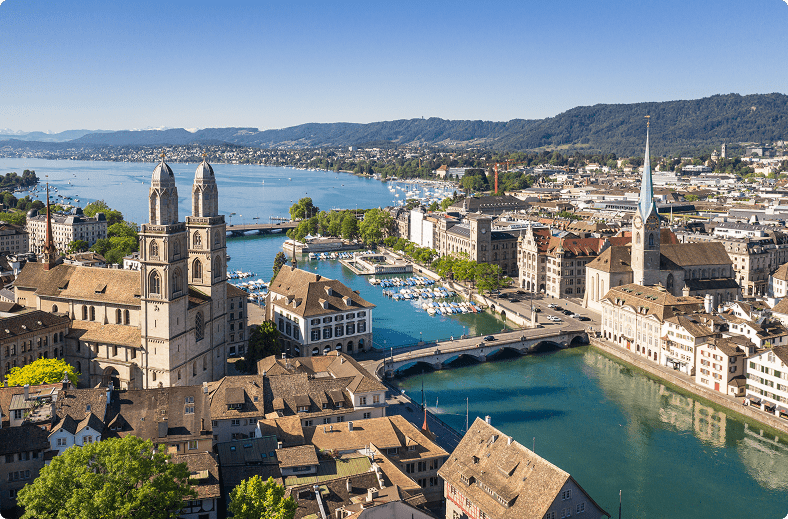 A scenic view of a city featuring a river and a bridge, showcasing urban architecture and natural elements.