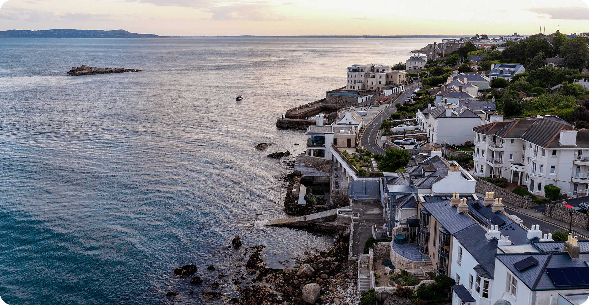 A city skyline with modern buildings, overlooking a tranquil body of water in the background.