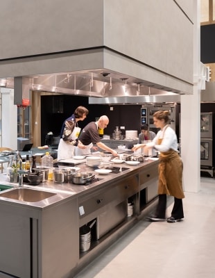 Hive Unilevers innovatiecentum vier personen die aan een groot kookeiland eten bereiden in het innovatiecentrum Hive in Wageningen