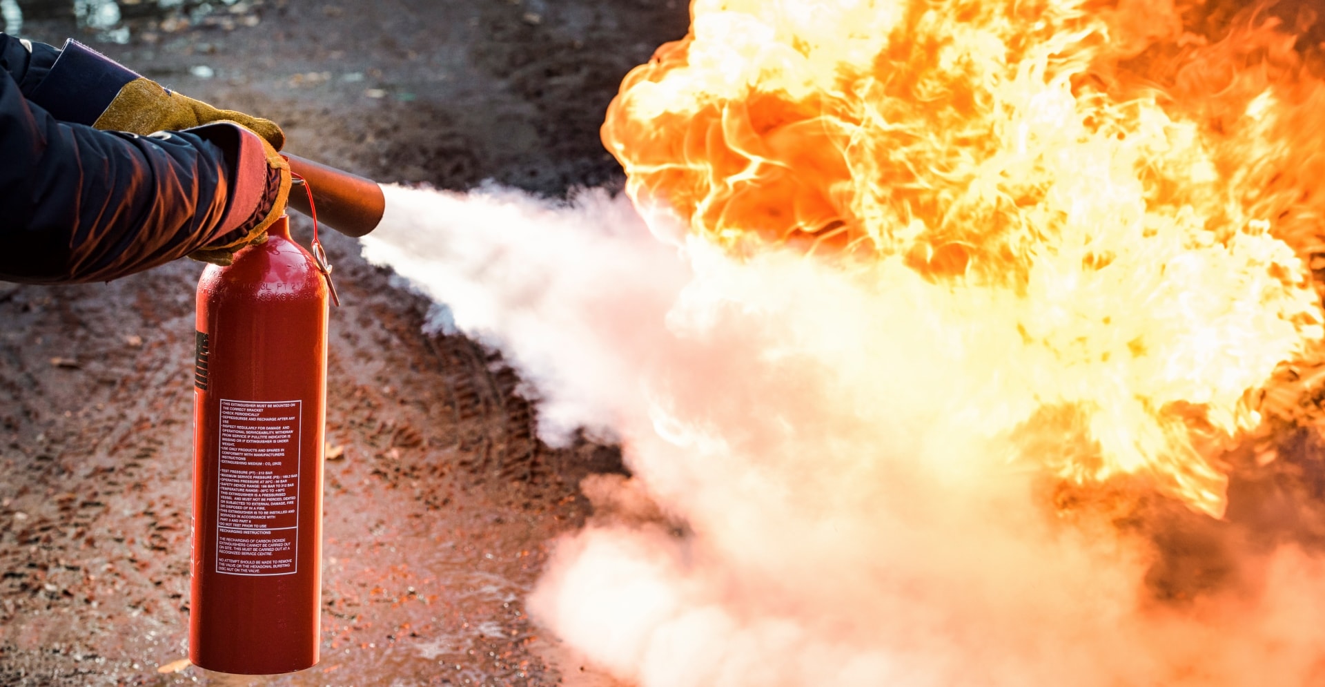 Persoon die een brand blust met een schuim uit een brandblusser