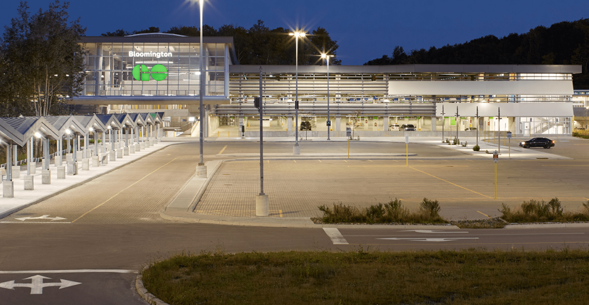 A spacious parking lot with numerous vehicles, featuring a large building in the background.