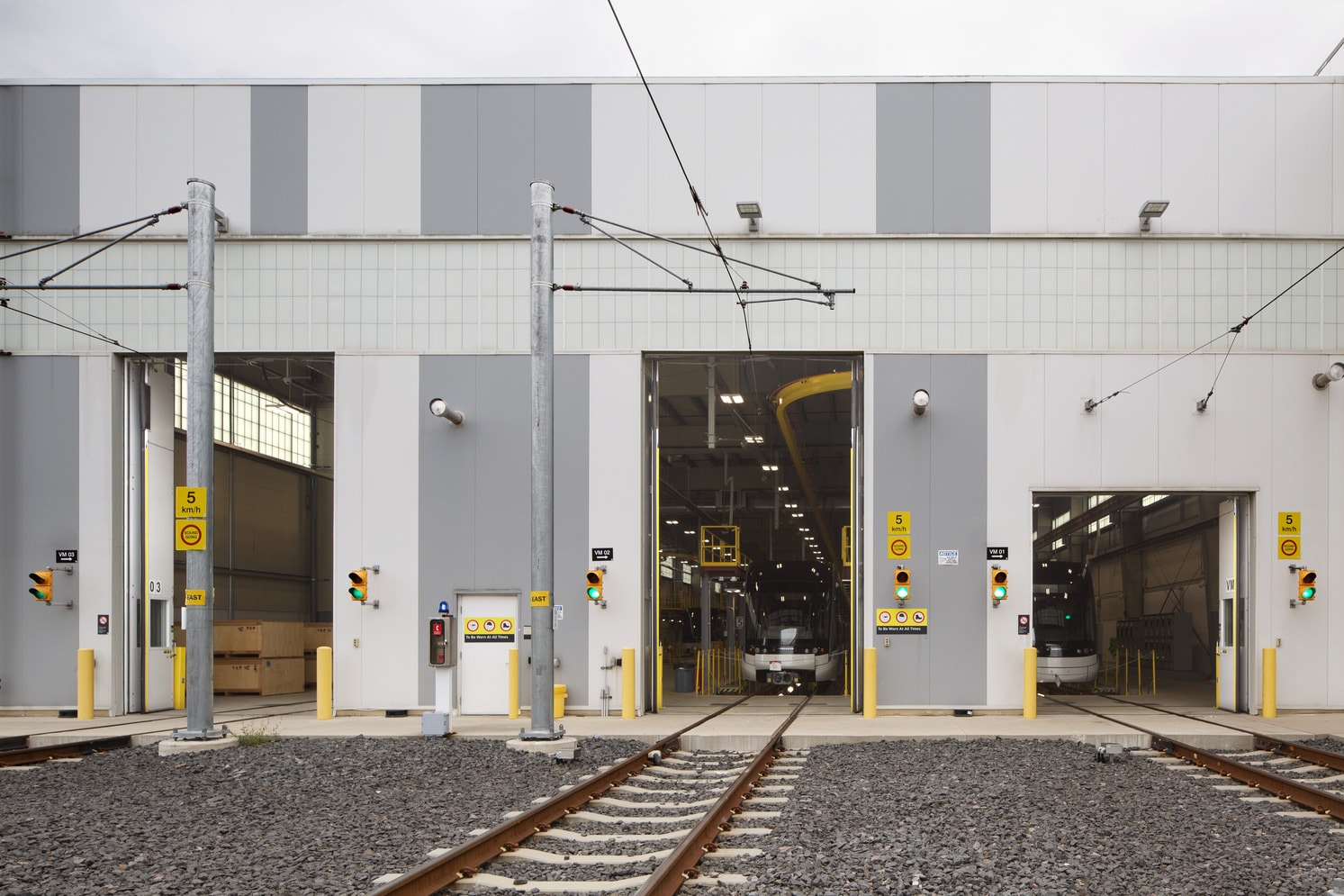 A train station featuring a train on the tracks, with platforms and signage visible in the background.