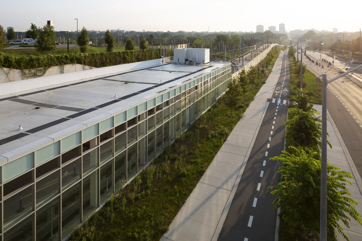 A large building featuring an expansive glass window that reflects the surrounding environment.