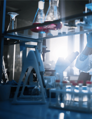 Two scientists wearing lab coats and masks while working on a research project.