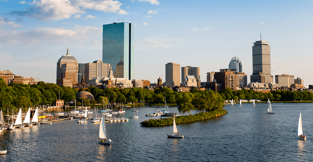 A serene body of water reflecting the sky, surrounded by lush greenery and distant hills.