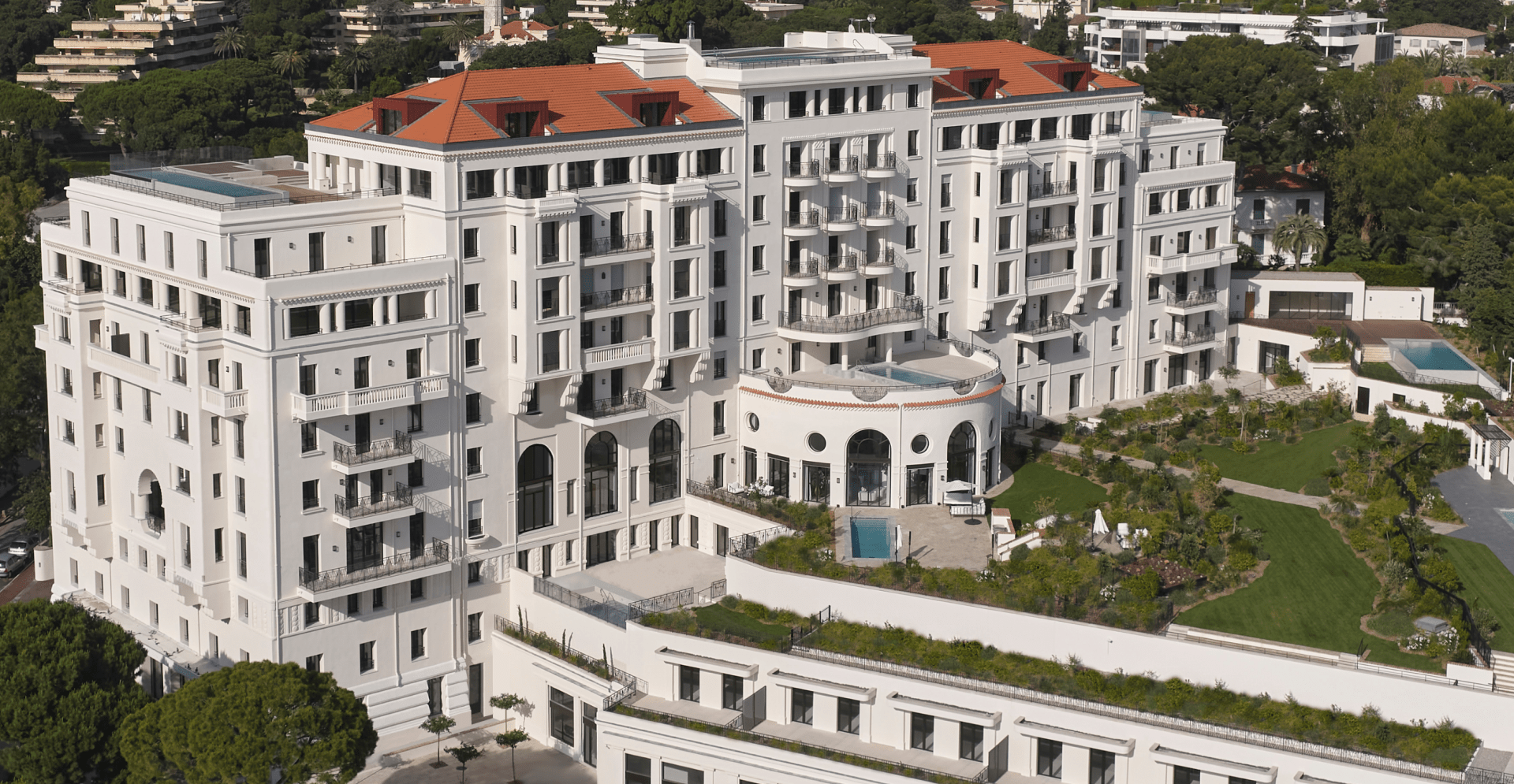 A white building is nestled among lush green trees, creating a serene and natural environment.